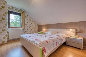 a bedroom with a large bed and a window at Gîte A La Violette in Trois-Ponts