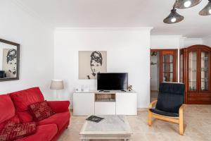 salon z czerwoną kanapą i telewizorem w obiekcie Federico 1 w mieście Conil de la Frontera