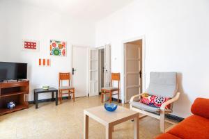 a living room with a couch and a tv at Apartamento Nicolas Only Families in Conil de la Frontera