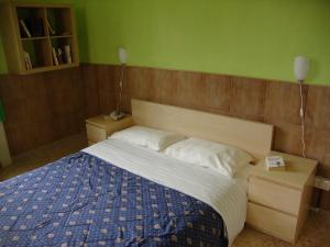 a bedroom with a bed with a blue and white comforter at La Maison des Livres in Reggio di Calabria