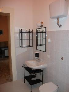 a bathroom with a sink and a toilet at La Maison des Livres in Reggio Calabria