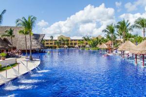 una piscina in un resort con palme di Barceló Maya Palace - All Inclusive a Xpu Ha