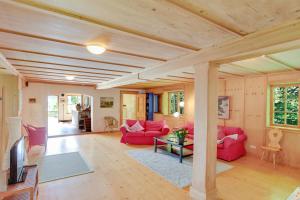 una sala de estar con muebles de color rojo y techo de madera. en Chalet am Brand, en Tegernsee