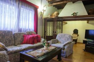 een woonkamer met een bank, 2 stoelen en een tv bij Can Murenu in Sant Joan de Labritja