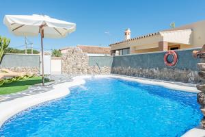 uma piscina com um guarda-sol e uma casa em Bungalows La Aceitera - Apartamento 1 em Zahora