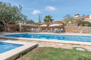 a swimming pool in a yard next to a house at Es Rafal Roig- S'arc in Sant Llorenç des Cardassar