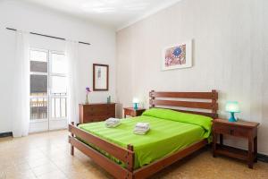 科尼爾－德拉弗龍特拉的住宿－Apartamento Nicolas Only Families，一间卧室配有一张带绿色床单的床和两张桌子