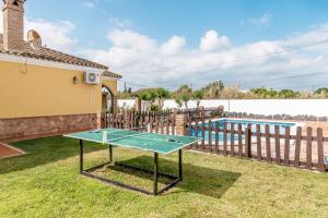 a ping pong table in a yard next to a pool at Casa Familiar La Lobita 1 in Conil de la Frontera