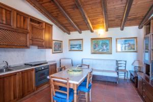 巴哈撒丁島的住宿－Casa Baja Sardinia，一间带桌椅的厨房和一间用餐室
