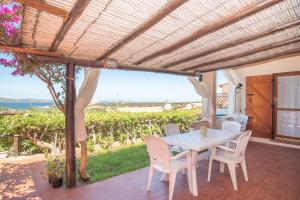巴哈撒丁島的住宿－Casa Baja Sardinia，海景露台配有桌椅