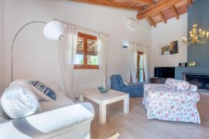 a living room with white furniture and a fireplace at Casa Yolanda in Sant Llorenç des Cardassar