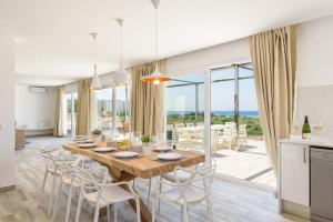 une cuisine et une salle à manger avec une table et des chaises dans l'établissement Villa Sunrise, à Son Bou