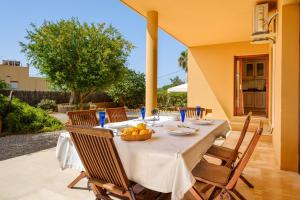 a dining table with a white table cloth and chairs at Villa Sunrise in Sant Josep de sa Talaia