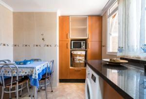 uma cozinha com uma mesa e cadeiras e um micro-ondas em Apartamento Mariam em Málaga