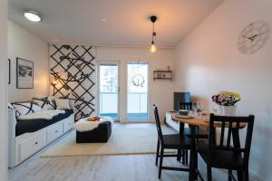 a bedroom with a bed and a table and a dining room at Vasko luxurious suites, Mustikka in Rovaniemi