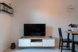 een woonkamer met een wit entertainmentcentrum met een flatscreen-tv bij Tuomas´ luxurious suites, Mustikka in Rovaniemi