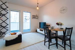 a dining room with a table and chairs and a television at Tuomas´ luxurious suites, Mustikka in Rovaniemi