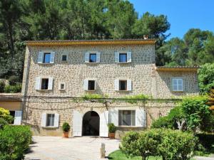 an old stone house with a courtyard in front at Finca es Verger des Port in Sóller
