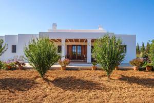 dom z dwoma drzewami przed nim w obiekcie Casa Cristina Ibiza w mieście Sant Carles de Peralta