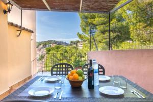 a table with a bowl of fruit and a bottle of wine at S'ancora in Port de Soller