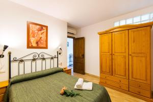 um quarto com uma cama verde e um armário de madeira em Apartamento Rural De Oses 2 em Totalán