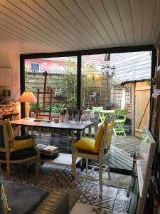 a screened in porch with a table and chairs at L'atelier de Jocelyne in Beuzeville