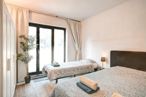 a bedroom with two beds and a large window at Light House Lodge. Apartment in Center of Antwerp in Antwerp
