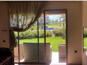 a sliding glass door with a view of a yard at bel appartement F2 au golf de Montgomery in Marrakesh
