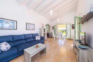 ein Wohnzimmer mit einem blauen Sofa und einem Tisch in der Unterkunft Sa caseta de la Mar in Son Servera