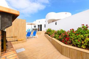 un patio con sillas y flores en un edificio en Villa Xana, en Playa Blanca