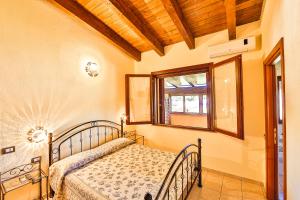 a bedroom with a bed and a window at Agriturismo Rocce Bianche in Arbus