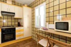 cocina con encimera con microondas y TV en Apartamento cerca de Cala Mitjana, en Cala Galdana