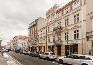 une rue de la ville avec des voitures garées dans la rue dans l'établissement Soft Loft 2 Apartment, à Toruń