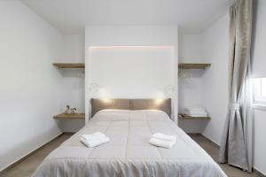 a bedroom with a white bed with two towels on it at Appartamenti Dama 1 in Bardolino
