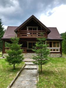 a log cabin with two trees in front of it at Котедж Гута in Guta