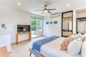 a bedroom with a large bed and a tv at La Escondida in Playa del Carmen