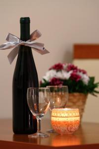 a bottle of wine and two wine glasses on a table at Petrovac Holiday Apartments in Petrovac na Moru