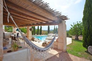 eine Terrasse mit einer Hängematte und einem Pool in der Unterkunft Finca Calicant in Sant Llorenç des Cardassar