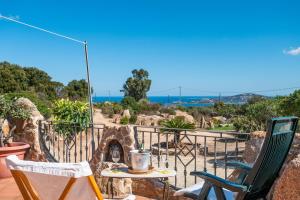 a patio with two chairs and a table and a fireplace at Sun House Appartamento Vista Mare in Cannigione