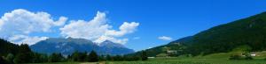 a green field with mountains in the background at AGRITURISMO MASO PERTENER -adults only- in Comano Terme