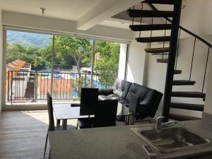 a living room with a table and a spiral staircase at Apartasol de Lujo Santa Fe de Antioquia" in Santa Fe de Antioquia