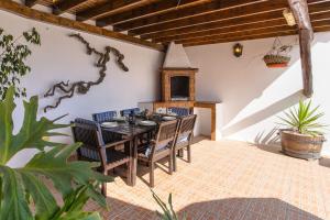 a dining room with a table and chairs on a patio at Finca La Rubina in Teguise