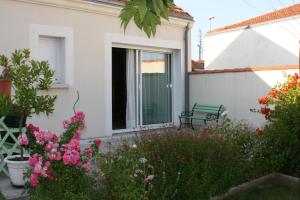 a garden in front of a house with flowers at Au Paradis des Hôtes in Fouras