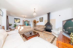 ein Wohnzimmer mit weißen Möbeln und einem Flachbild-TV in der Unterkunft Los tres soles in Portocolom