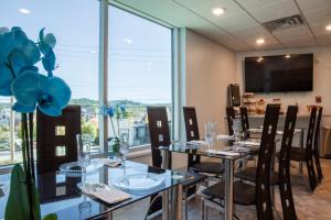 a restaurant with tables and chairs and a large window at Athens Central Hotel in Athens