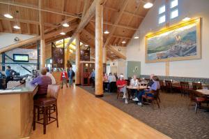 a group of people sitting at tables in a restaurant at Grande Denali Lodge by Aspen Hotels in McKinley Park