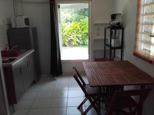 uma cozinha com uma mesa e uma mesa e uma janela em Residence Acacia em Belle-Allée