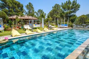 ein Pool mit gelben Kissen und Stühlen um ihn herum in der Unterkunft Villa Sarahmuk in Sant Antoni de Portmany