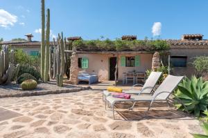 une terrasse avec deux chaises et une maison avec un cactus dans l'établissement Es Rafal Roig - Es Nou, à Sant Llorenç des Cardassar