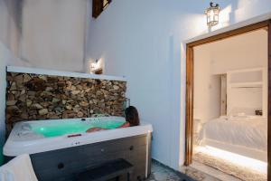 a woman sitting in a bath tub in a bedroom at Blue Mountain Guesthouse by Seablue in Arachova